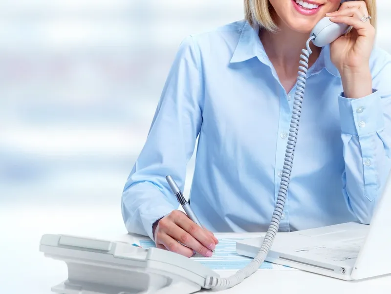 rs=w_800,h_602,cg_true (3) A woman sitting at her desk talking on the phone.